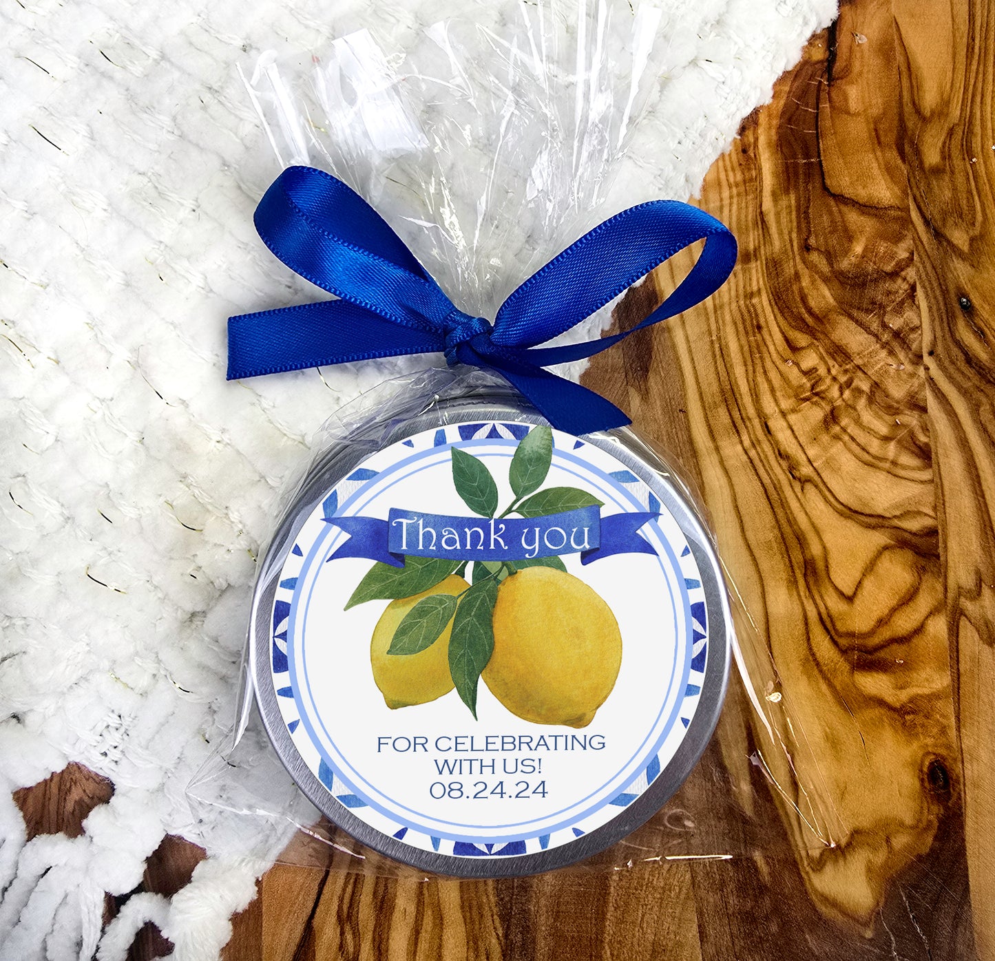 a round ornament with a blue ribbon and a thank you for celebrating with