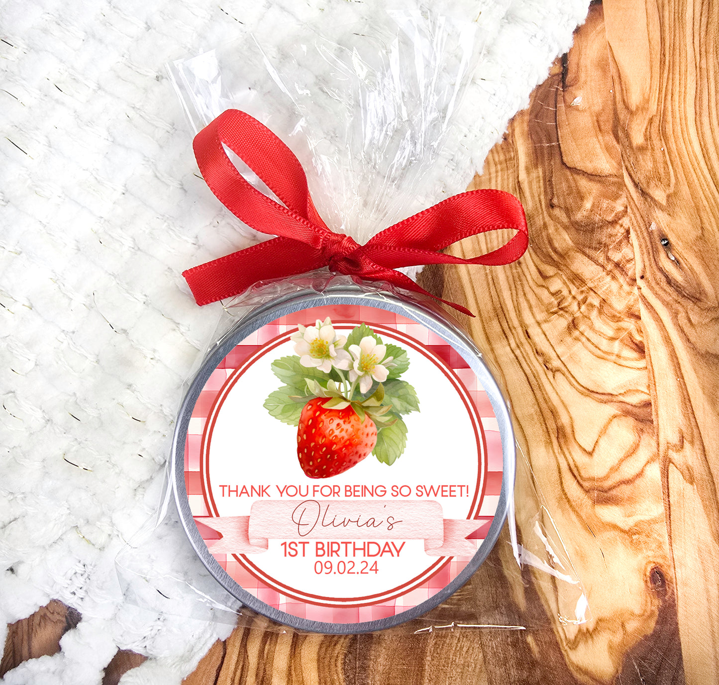 a round personalized birthday ornament with a red ribbon