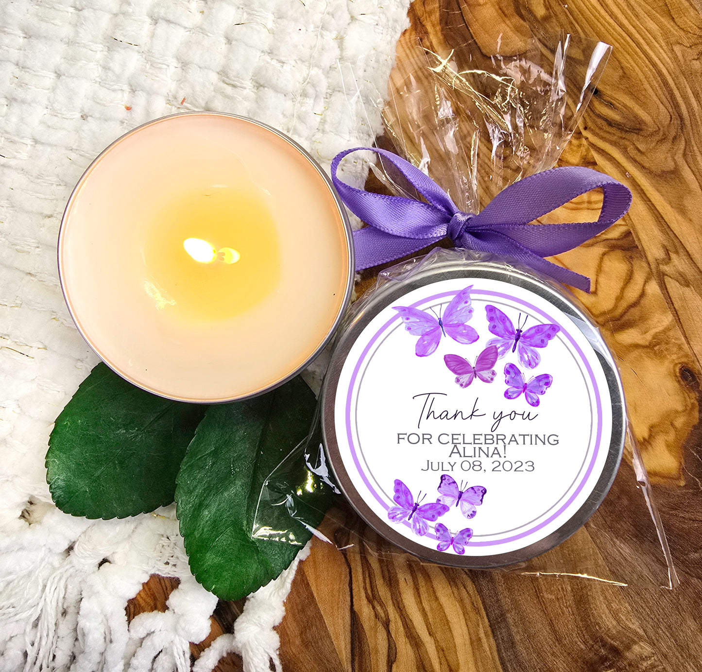 a candle with a purple ribbon next to it