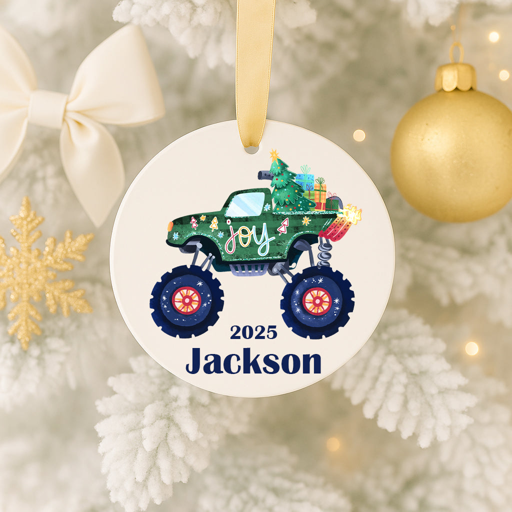A Christmas ornament featuring a green monster truck with a Christmas tree on the back, hanging on a tree.