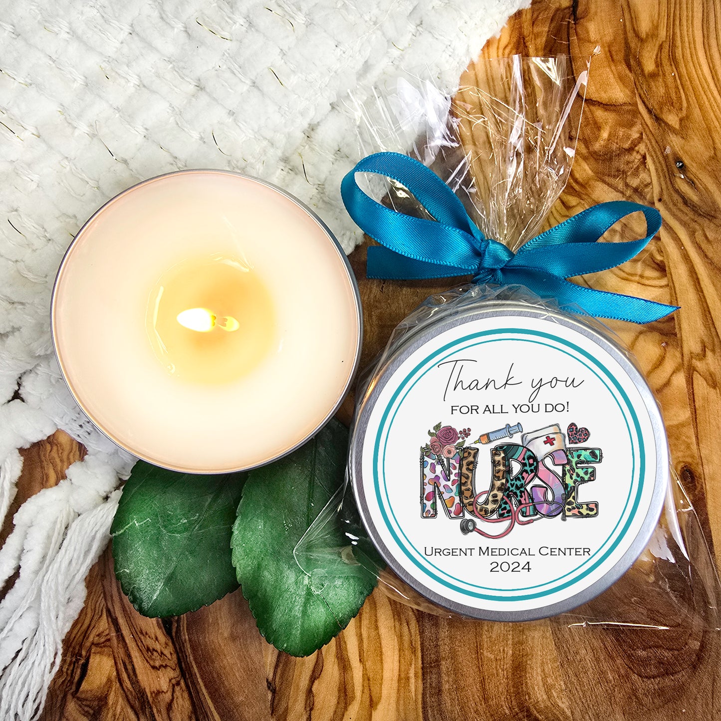 a white candle and a blue ribbon on a wooden table