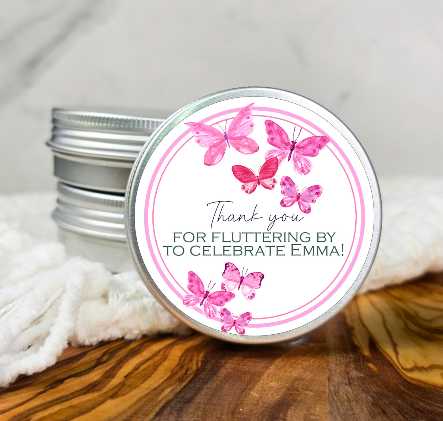 a tin of pink butterflies on a white background