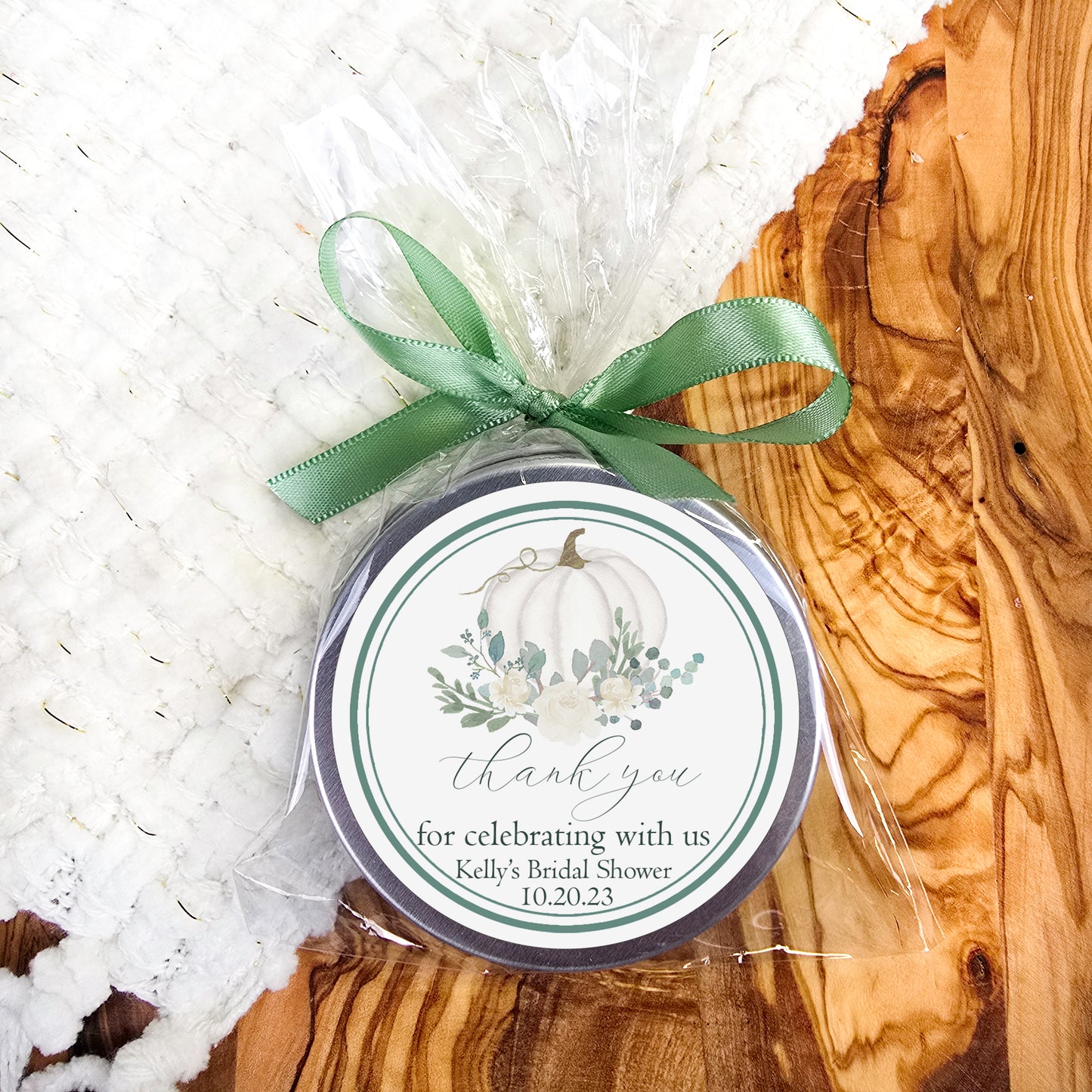 a small jar with a green ribbon around it