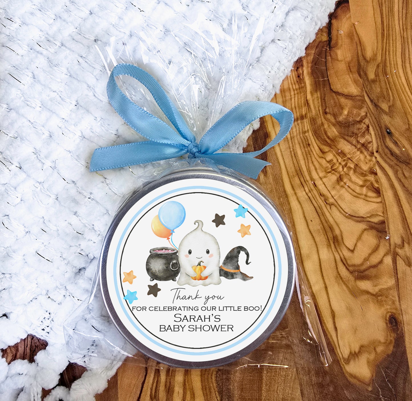 a small tin of baby shower gel sitting on top of a wooden table