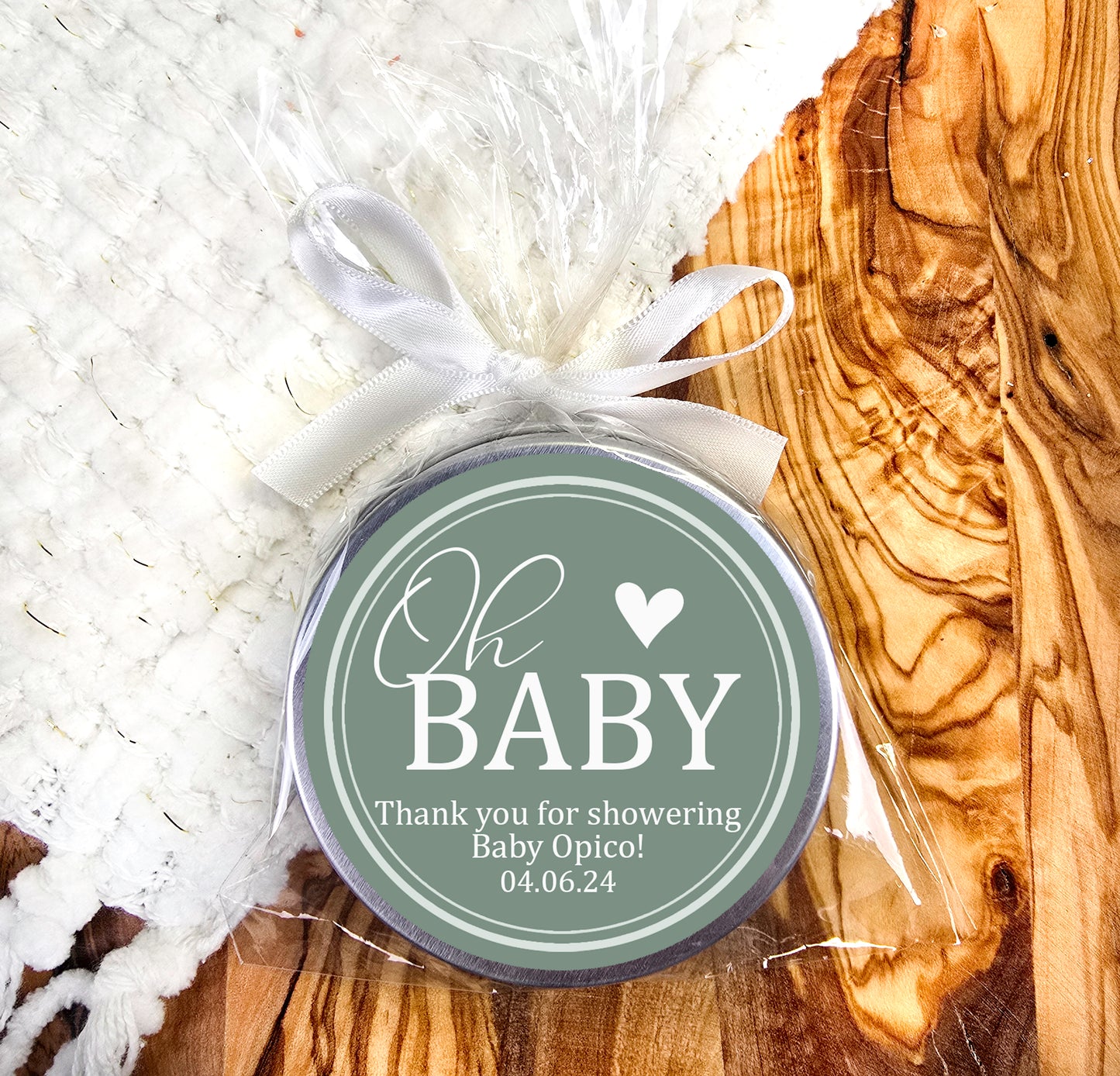 a baby shower tag sitting on top of a wooden table