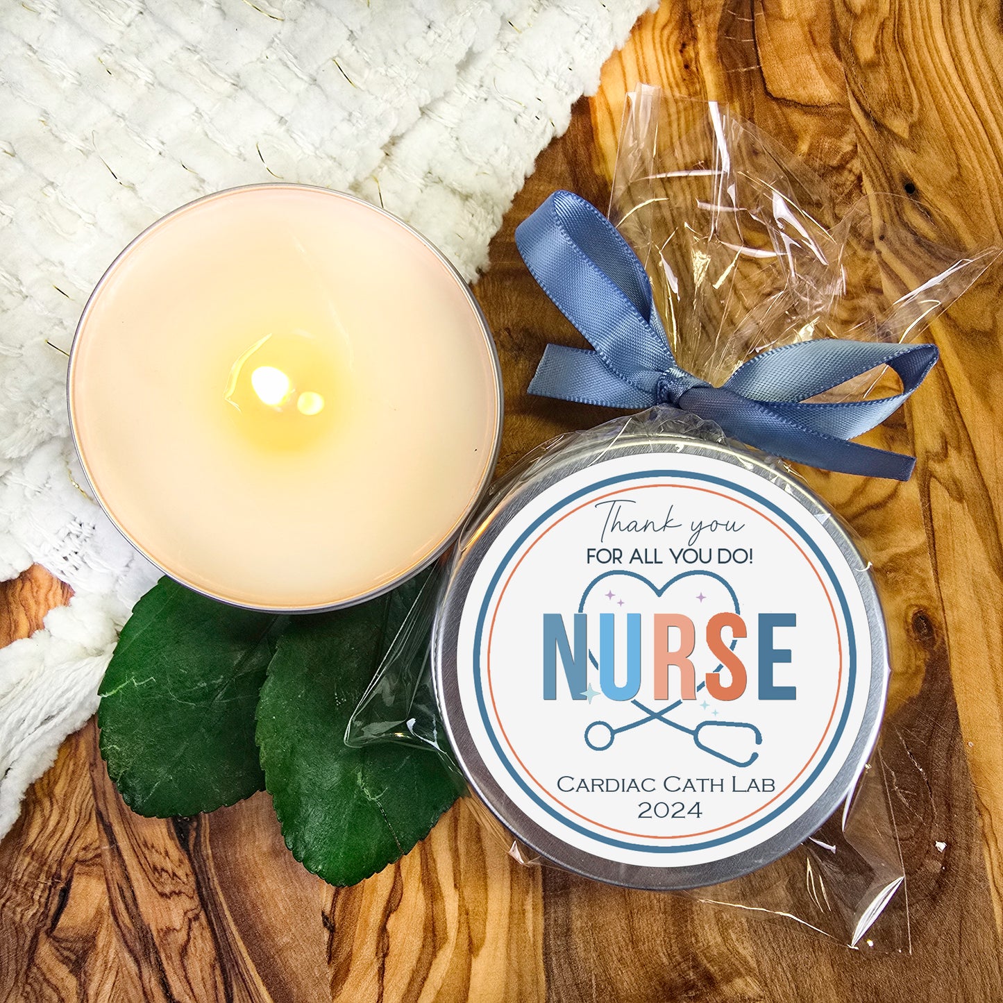 a candle with a blue ribbon next to it