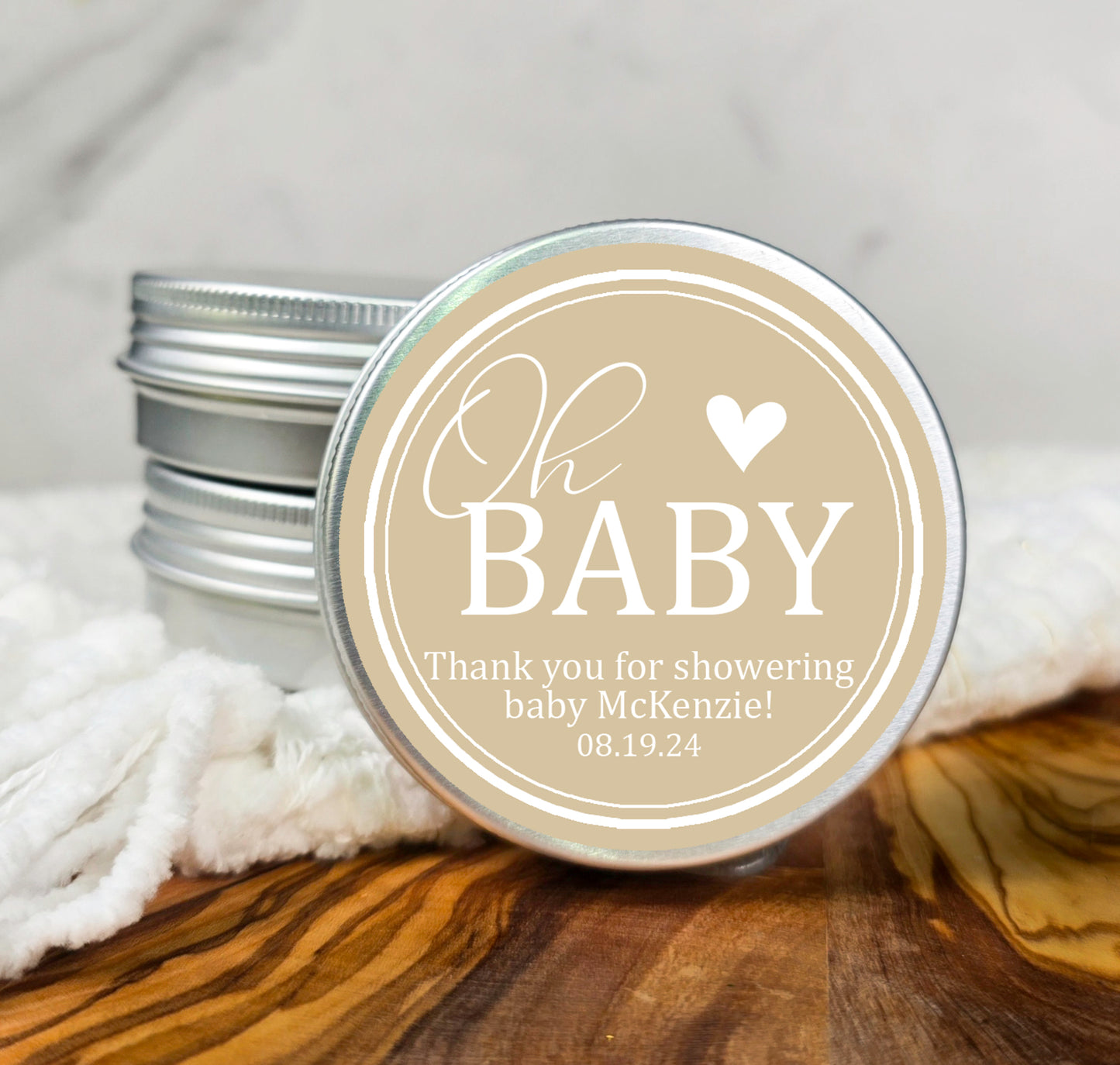 a small tin of baby shower lotion sitting on top of a wooden table