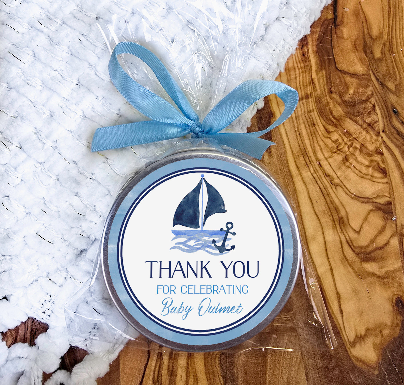 a small tin with a blue ribbon around it