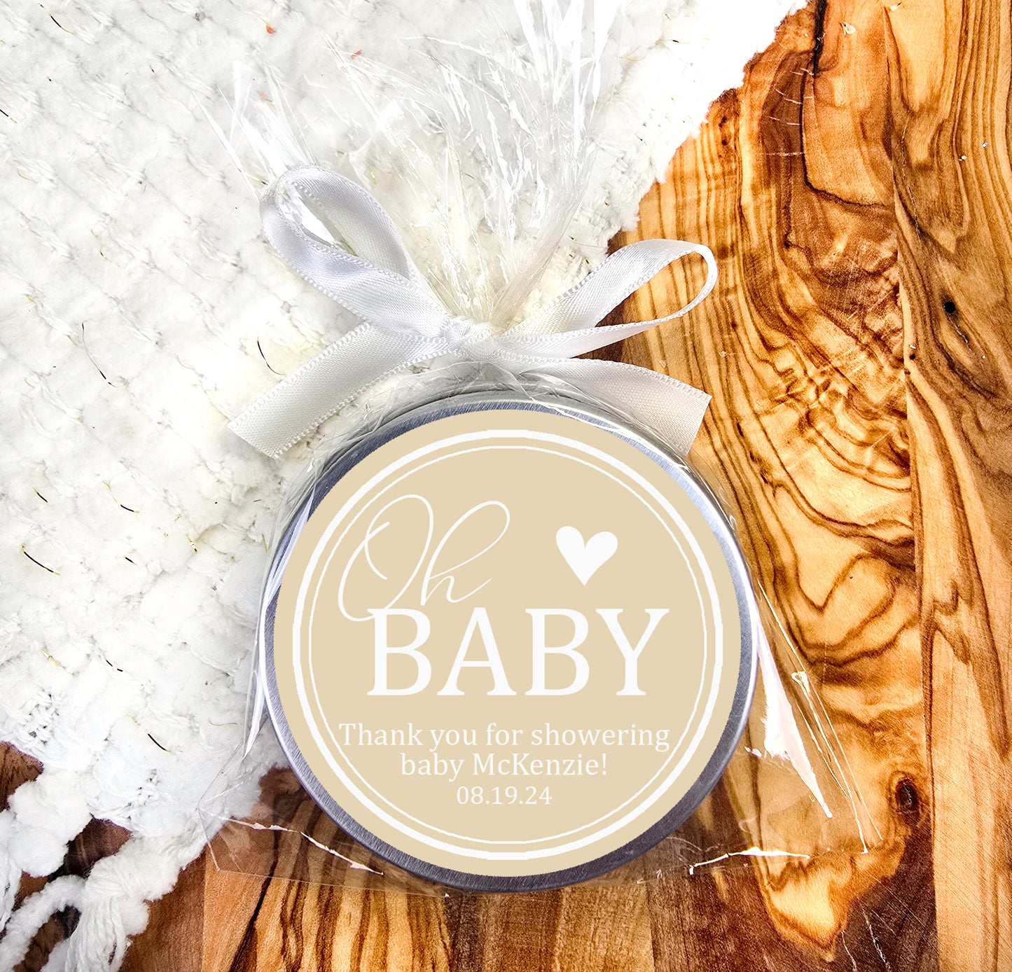 a baby shower tag sitting on top of a wooden table
