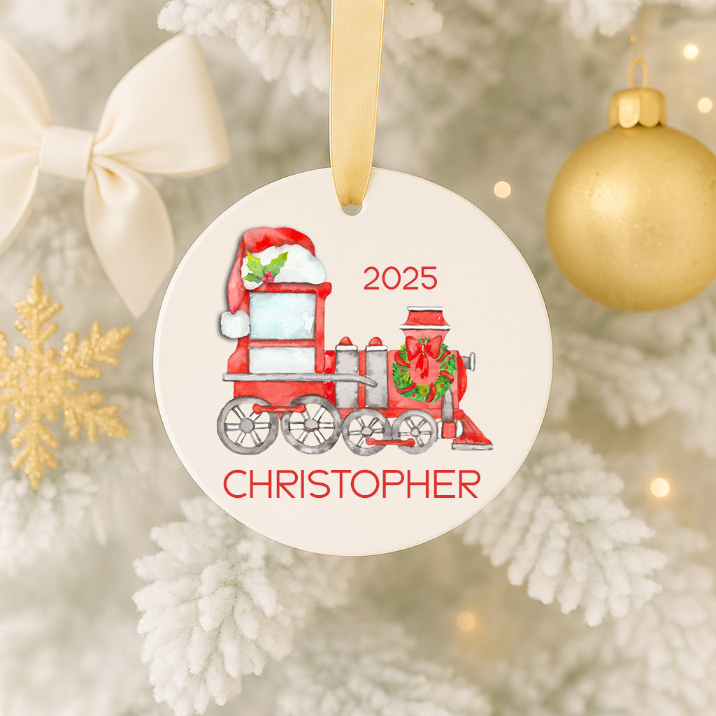 A Christmas ornament featuring a red and white train with a Santa hat, and the name "CHRISTOPHER" written on it.