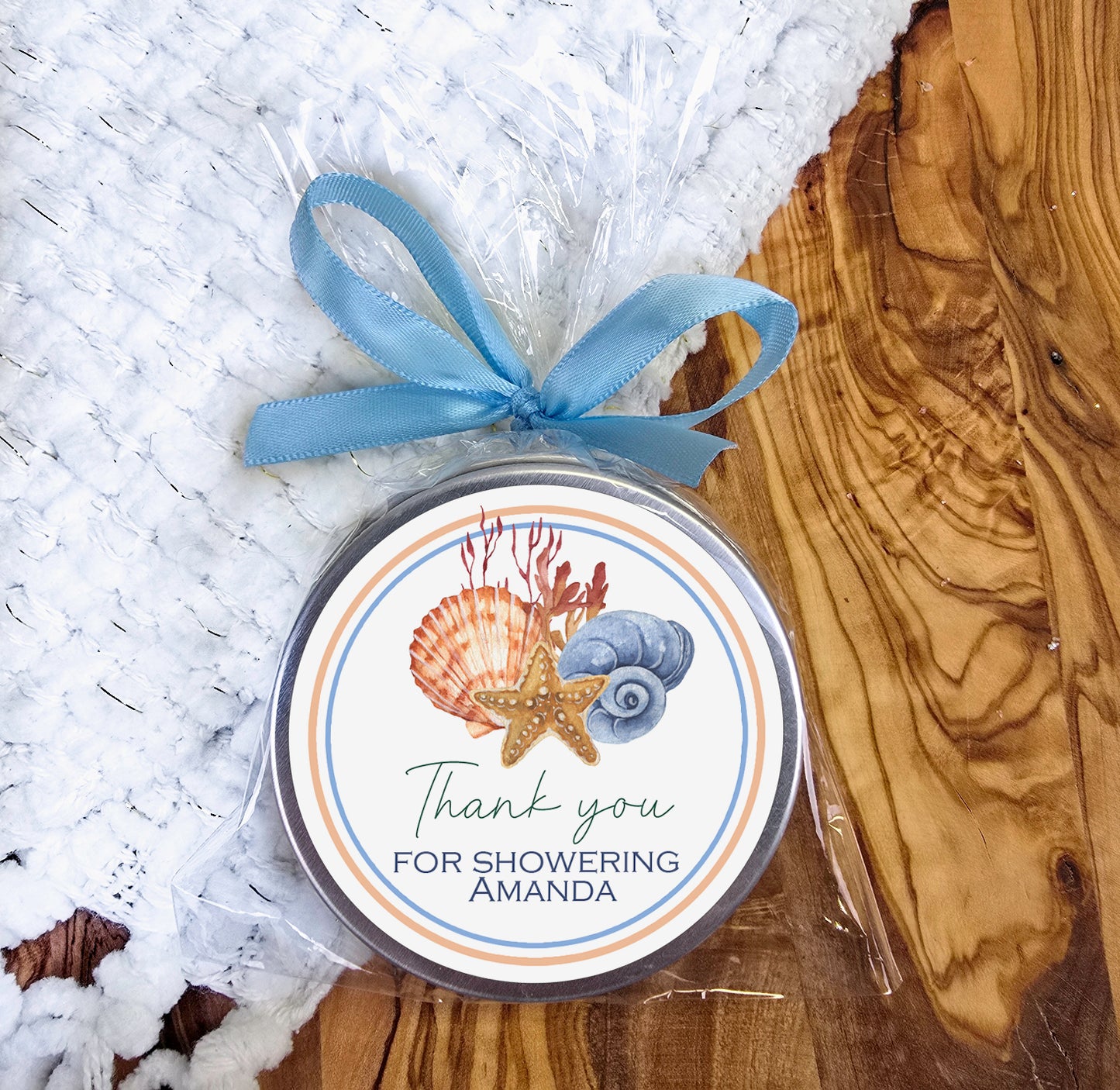 a jar of sea shells with a blue ribbon