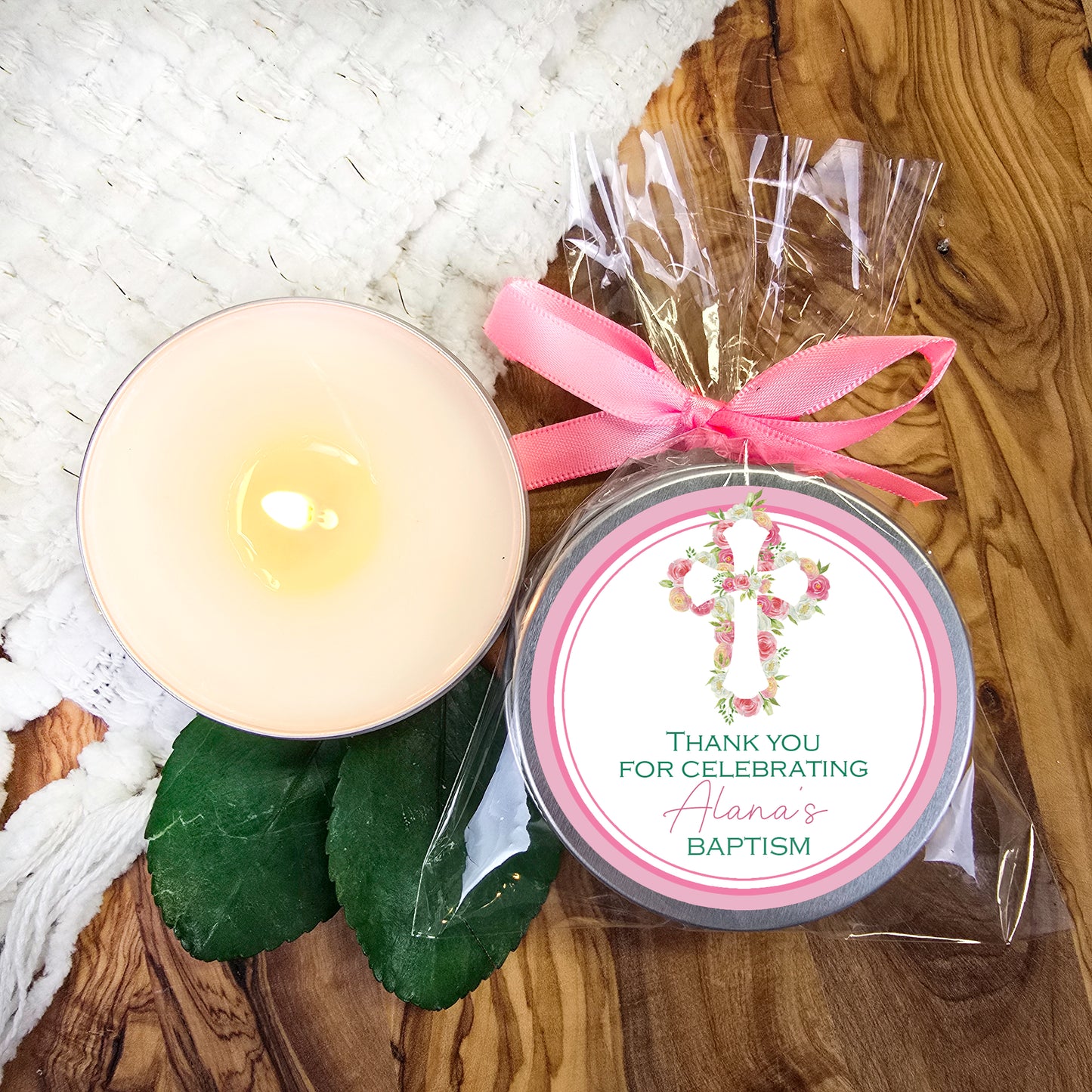 a candle with a pink ribbon on a table