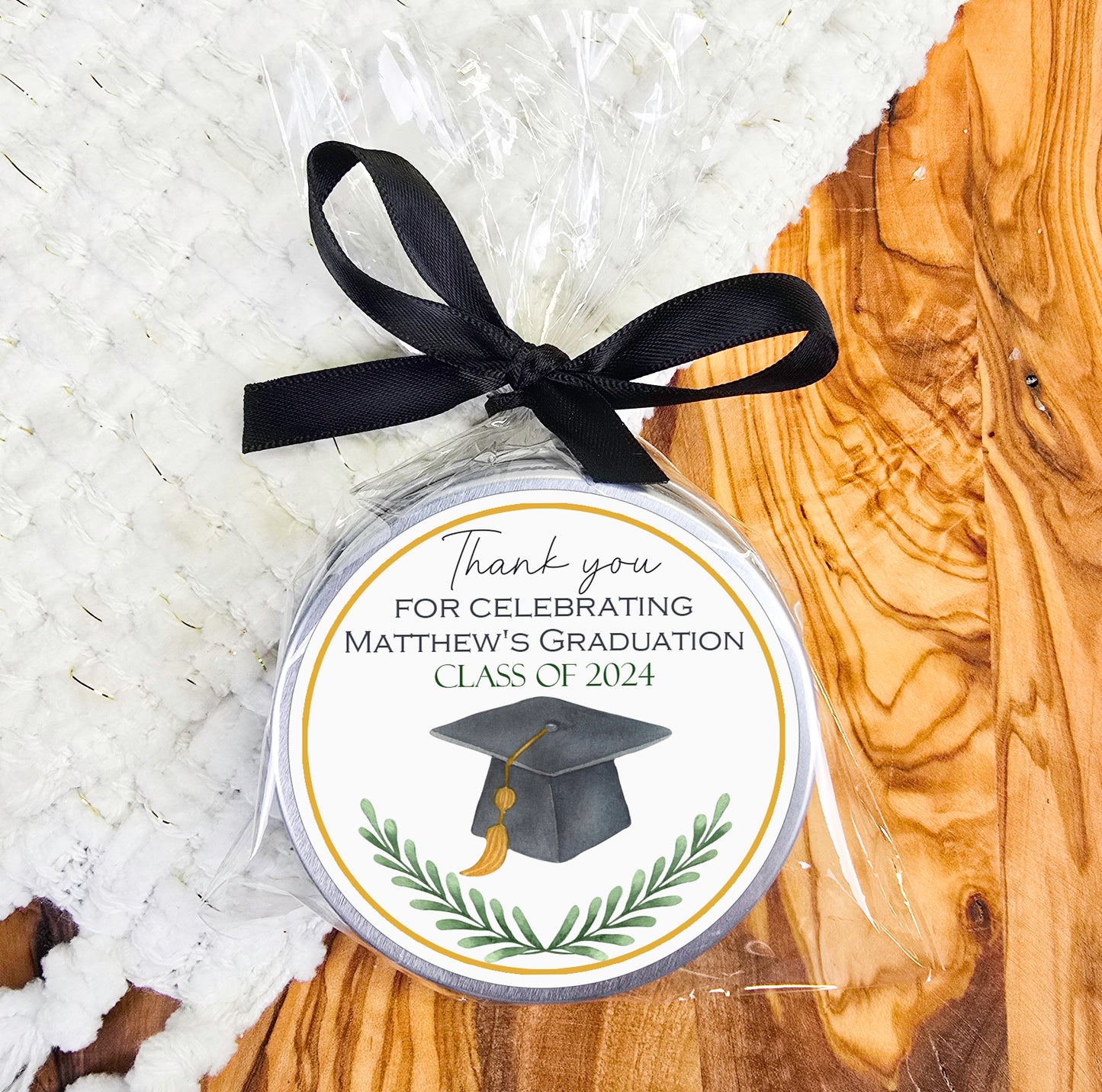 a graduation ornament with a black ribbon on a wooden table