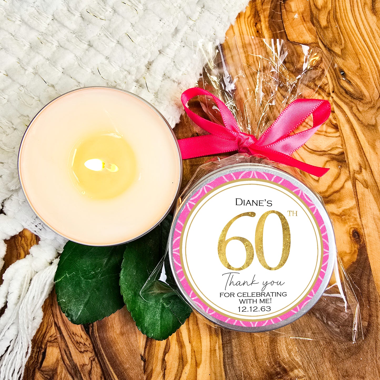 a candle with a pink ribbon next to it