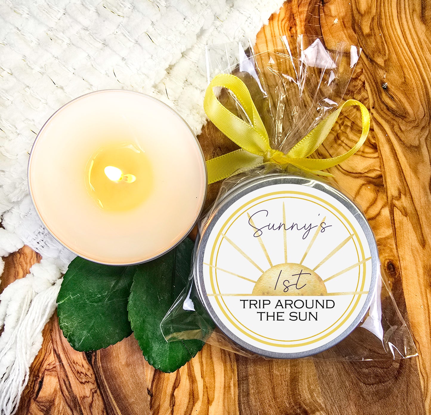 a candle next to a packaged candle on a wooden table