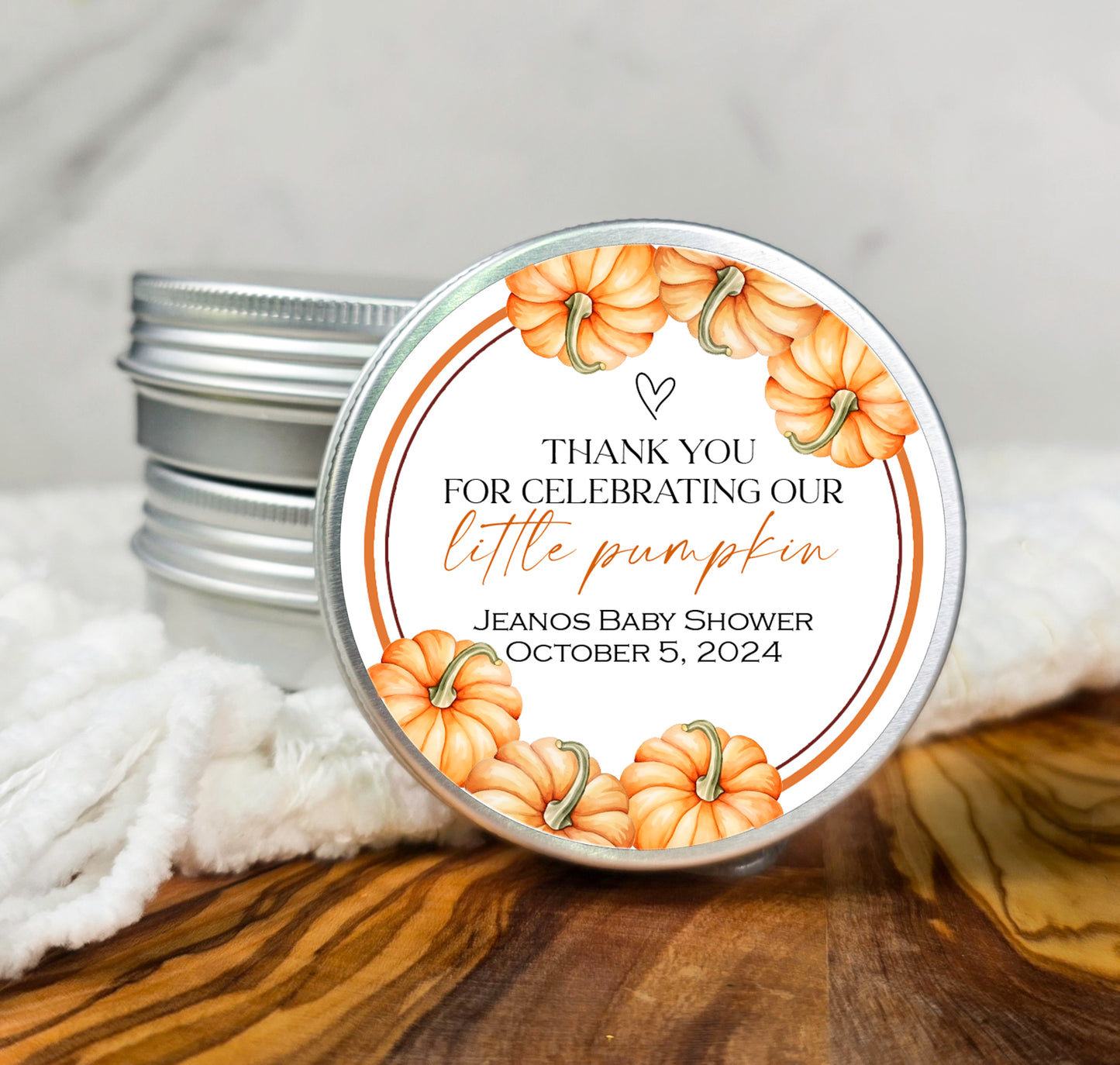 a small tin of baby shower lotion sitting on top of a wooden table