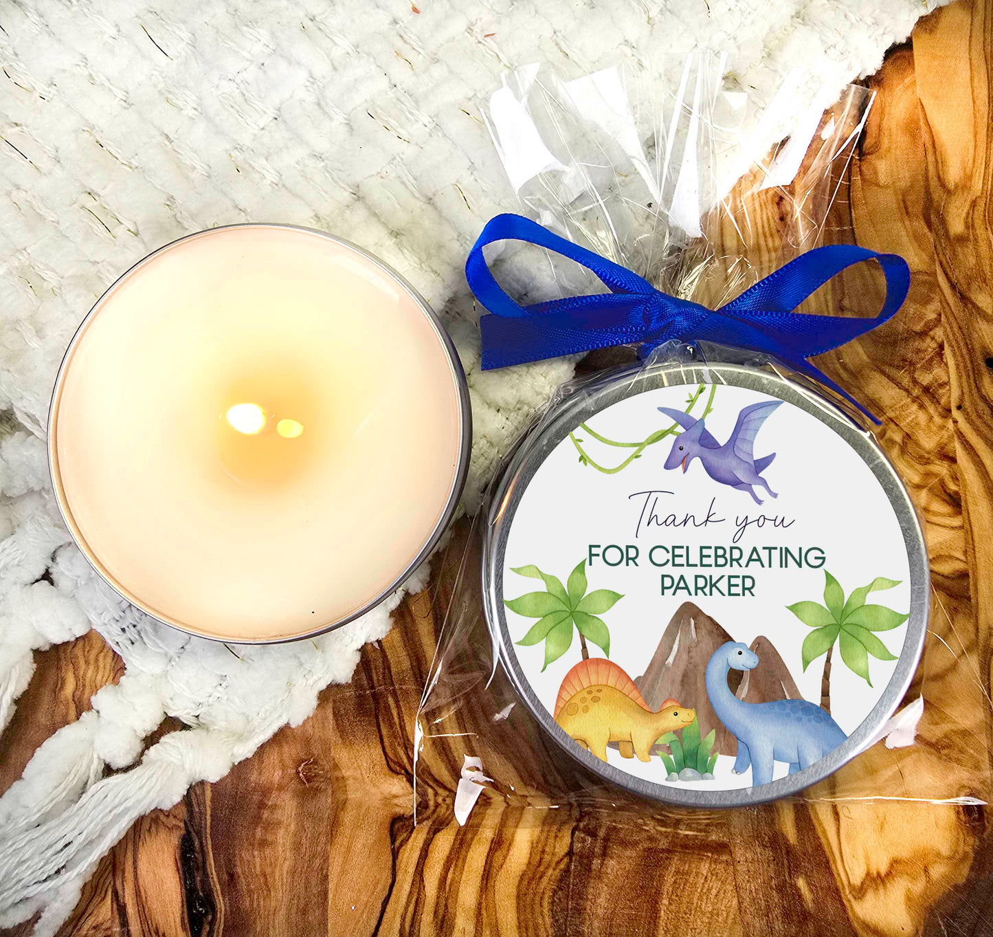 a candle and a tin with a blue ribbon