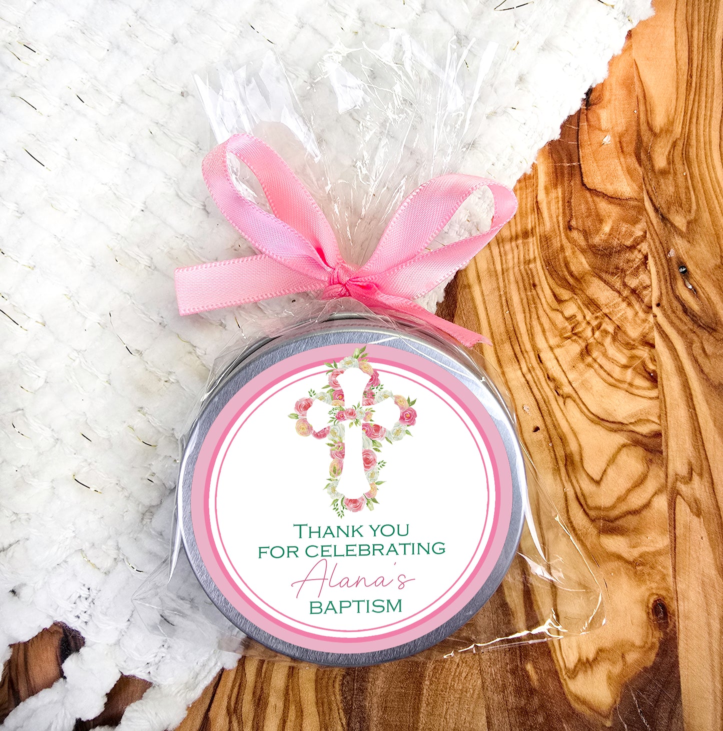 a small tin with a pink ribbon around it
