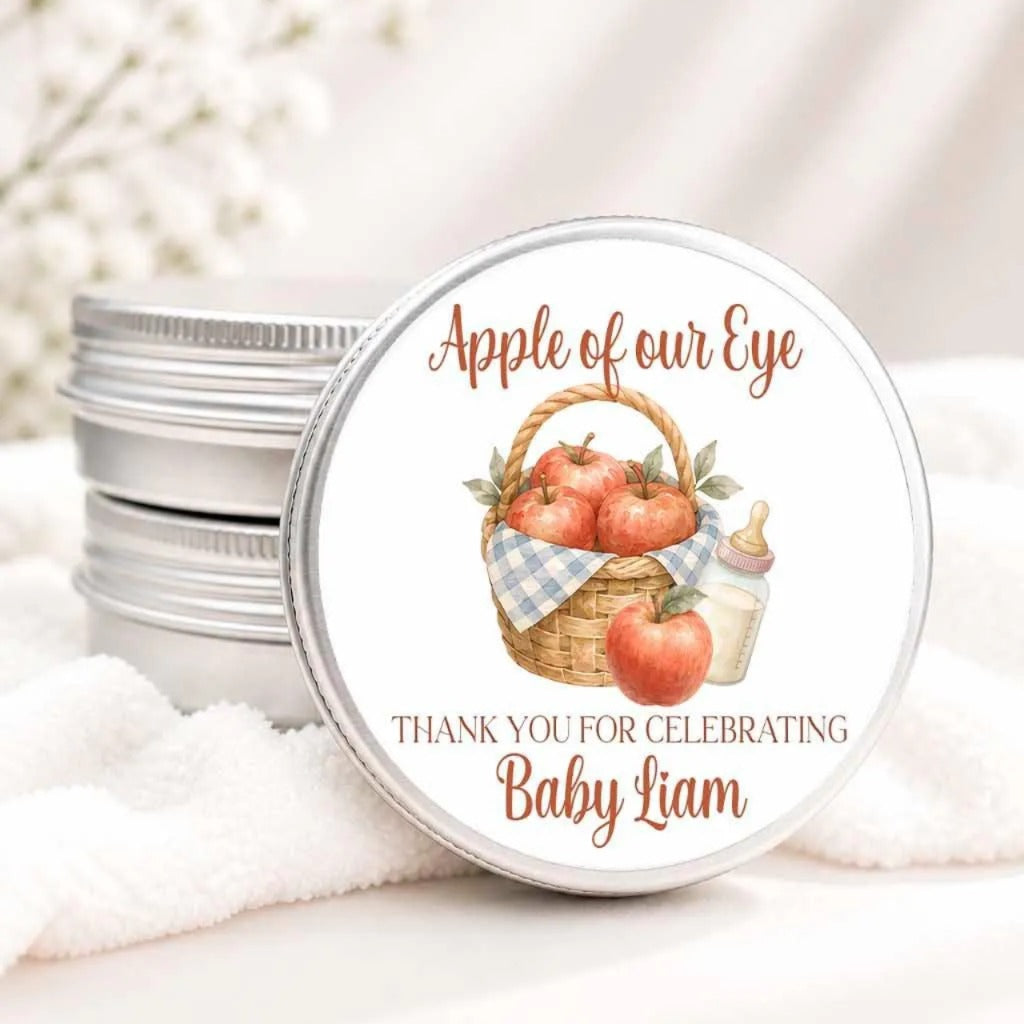 A round tin lid with a label that says "Apple of our Eye" and "Thank you for celebrating Baby Liam".