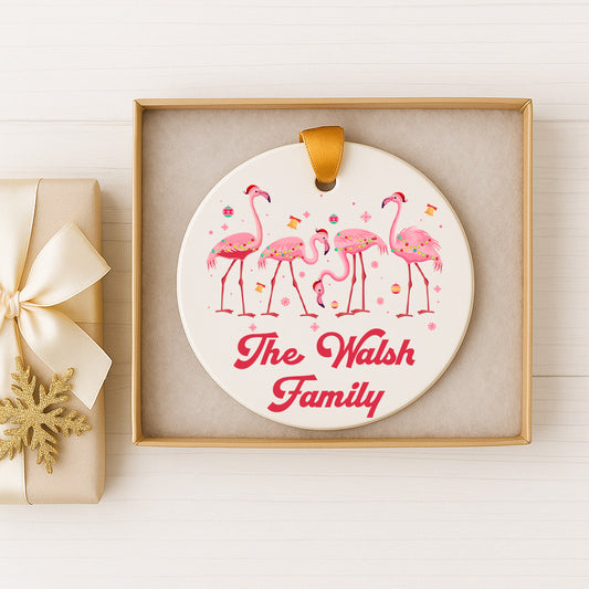 A white ornament with pink flamingos and the text "The Walsh Family" is displayed in a gold box on a white background.