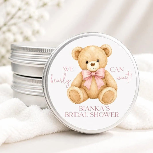 A round tin lid with a teddy bear illustration and text, placed on a white cloth.