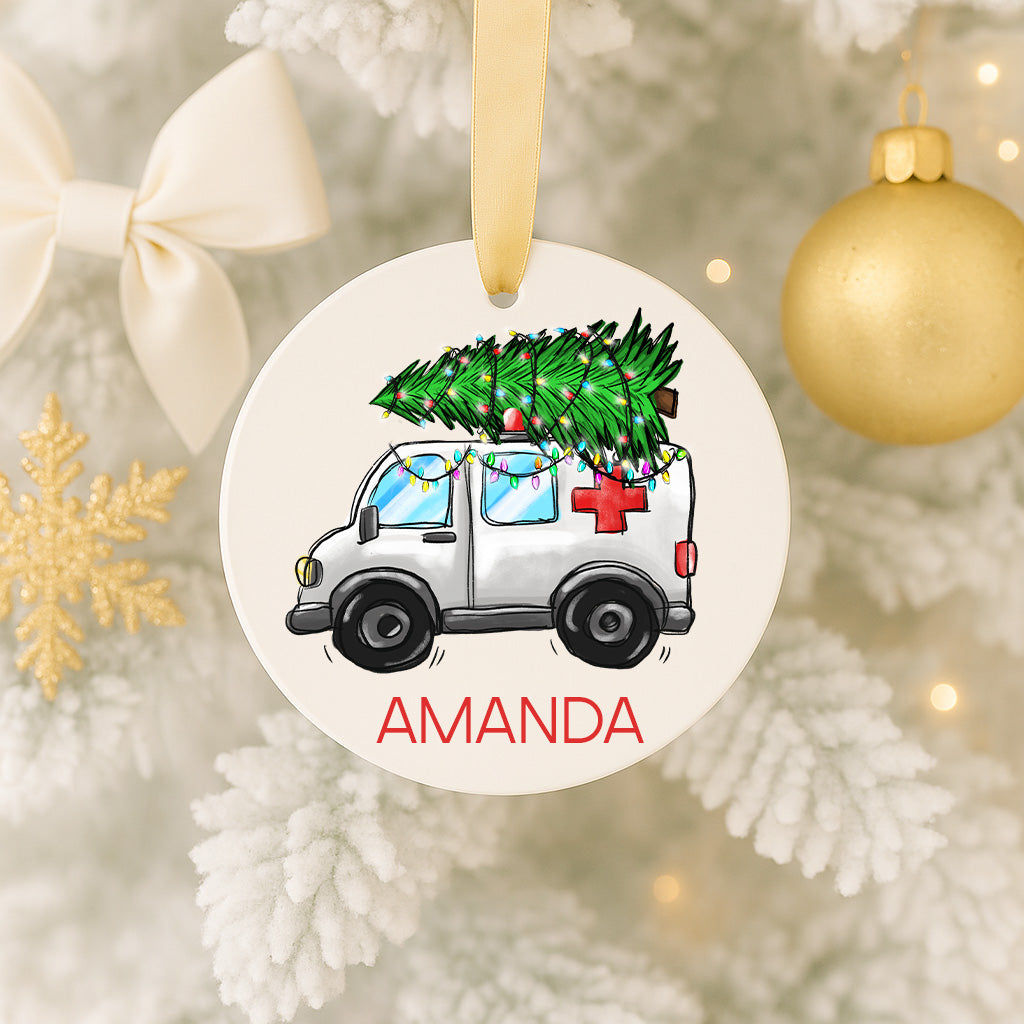 A Christmas ornament featuring a white ambulance carrying a decorated Christmas tree.