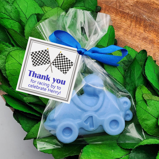 a blue train ornament sitting on top of green leaves