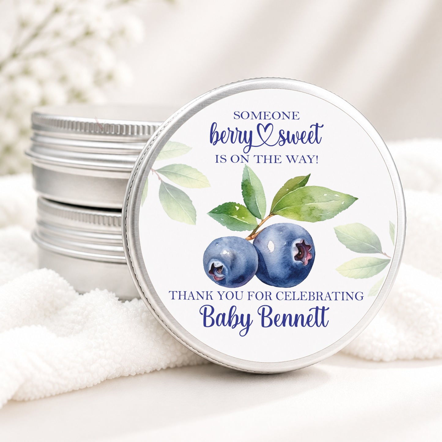Personalized blueberry baby shower candle favor in a silver tin featuring watercolor blueberries and the phrase "Someone Berry Sweet Is On The Way" with custom baby shower personalization.