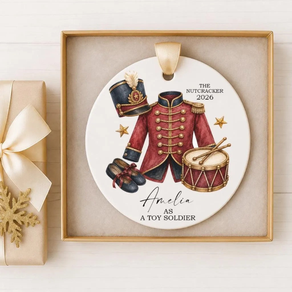 A decorative ornament featuring a red military uniform, a hat, and a drum, with the text "The Nutcracker 2016" and "Amelia as a Toy Soldier" displayed on it.