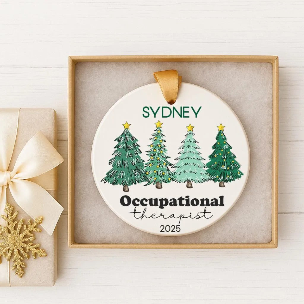A white ornament with a gold ribbon, featuring a circular design with illustrations of four green Christmas trees and the text "SYDNEY Occupational Therapist 2025".