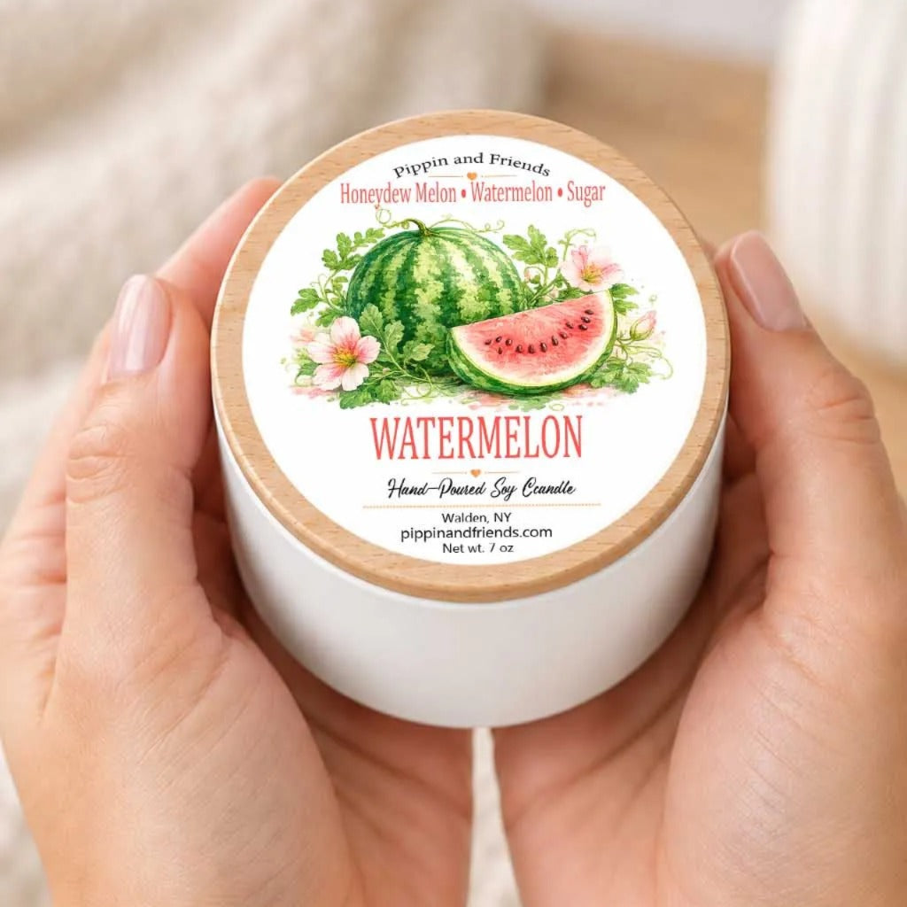 A person's hands holding a white container with a label featuring an illustration of a watermelon surrounded by flowers.