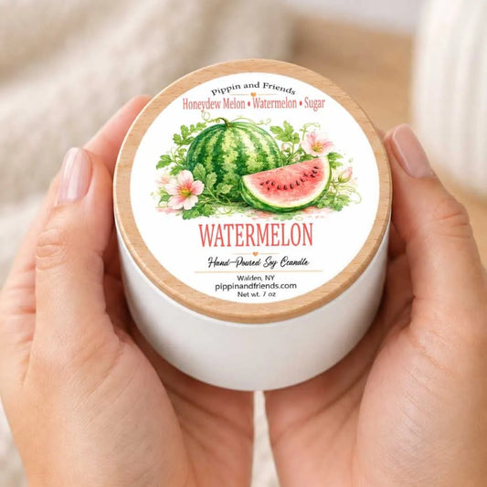 A person's hands holding a white container with a label featuring an illustration of a watermelon surrounded by flowers.