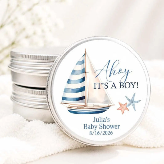 A round tin can with a sailboat illustration and text, likely a baby shower gift label.