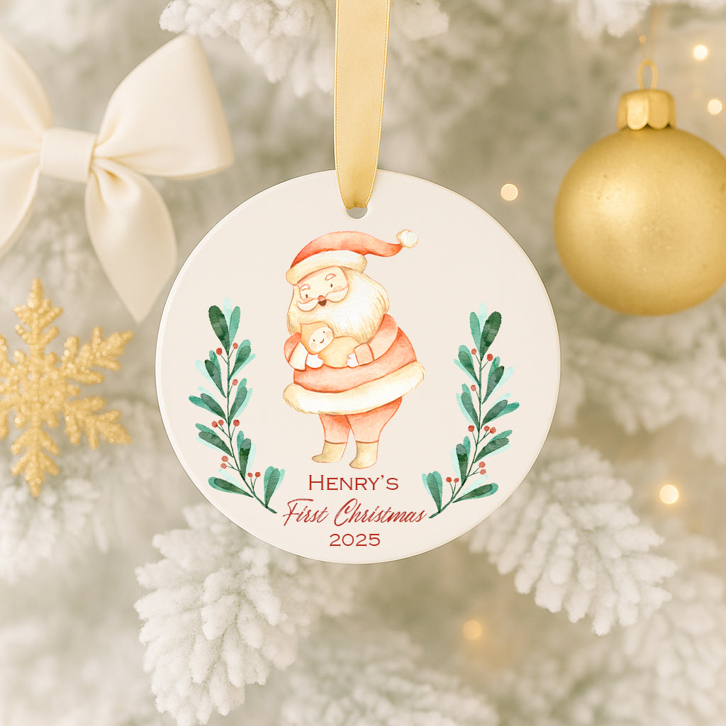 A white ornament with a Santa Claus illustration and the text "HENRY'S FIRST CHRISTMAS 2005" hangs on a Christmas tree.