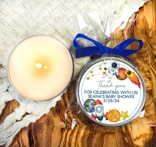 a candle and a personalized christmas ornament on a table