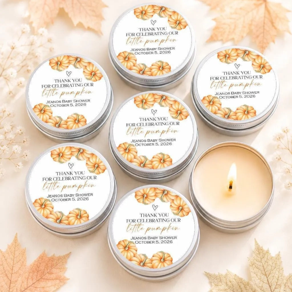 six silver tins with white labels, each featuring a design of orange pumpkins and text that reads "Thank you for celebrating our little pumpkin" and "Jeano's baby shower October 5, 2016". The tins are arranged in a circular pattern on a white background, with some of them open to reveal the candles inside.