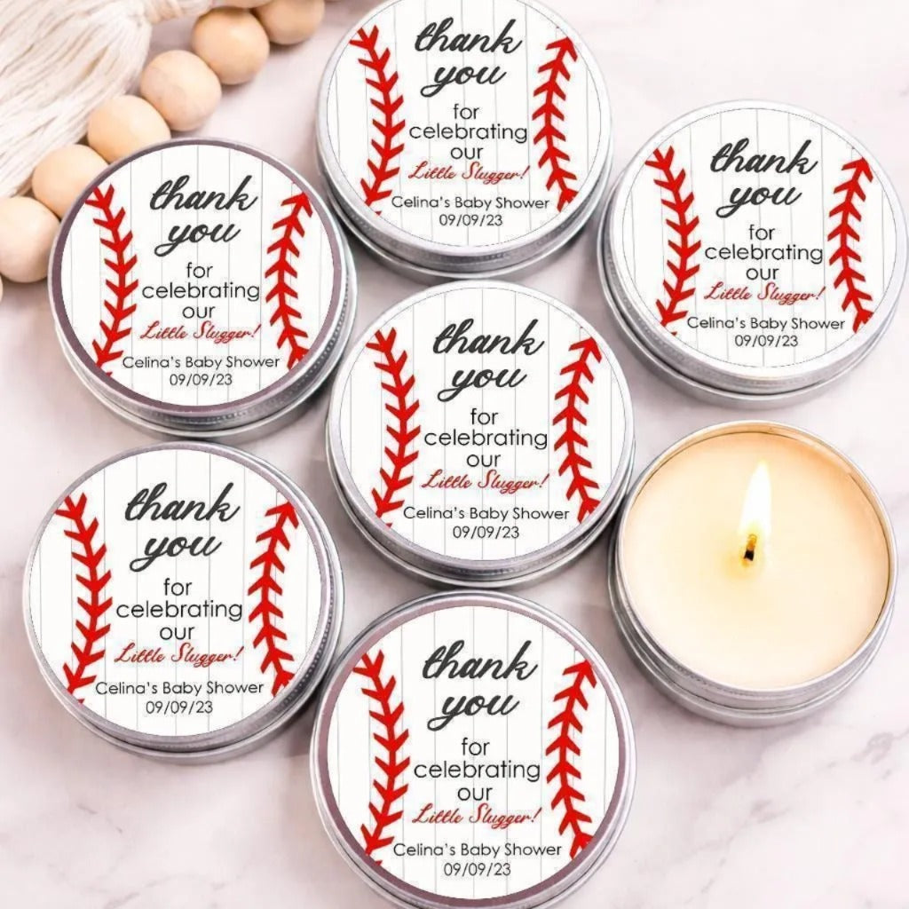 six silver tin candles with red baseball-themed labels, arranged on a marble surface. The labels express gratitude for celebrating a baby shower, with the names Celina and the date 09/09/23.