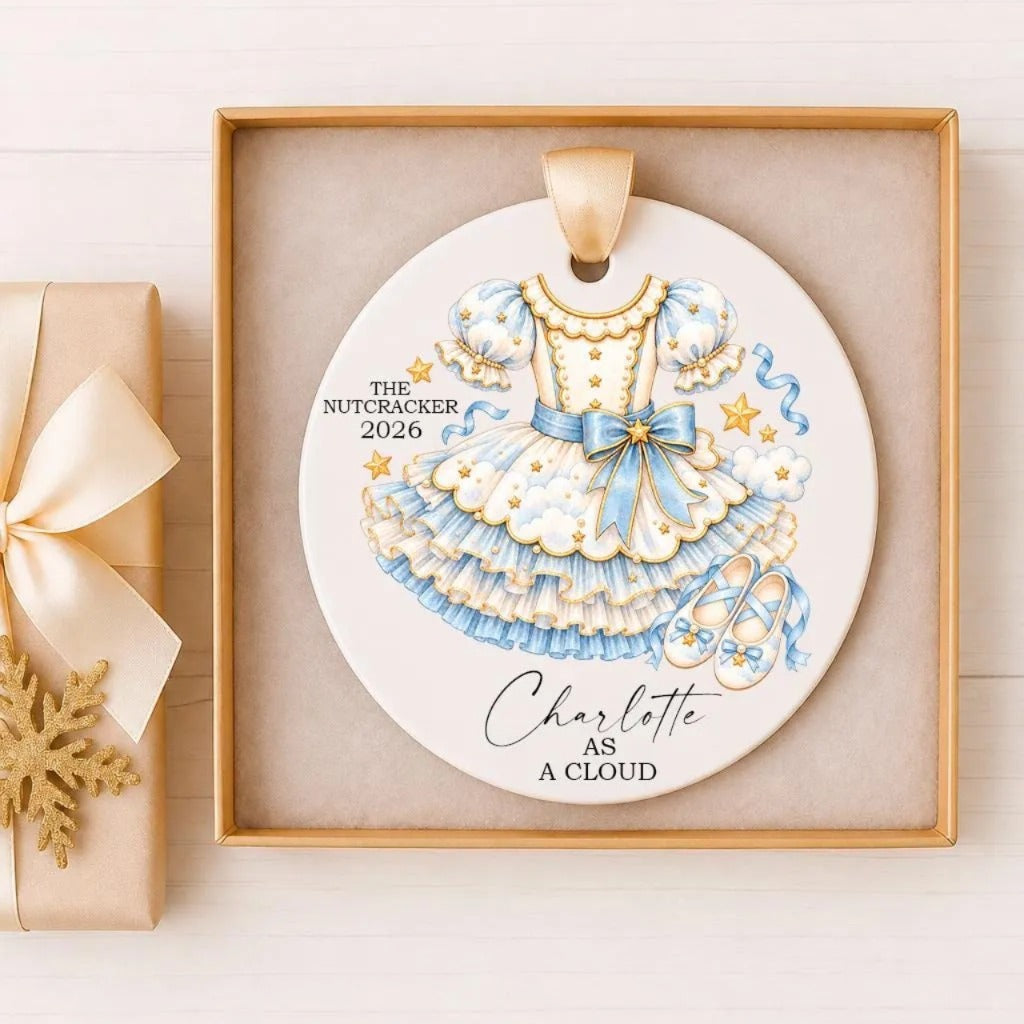 A decorative ornament featuring a blue and gold dress with a bow, surrounded by stars and clouds, and the text "The Nutcracker 2016" and "Charlotte as a cloud".
