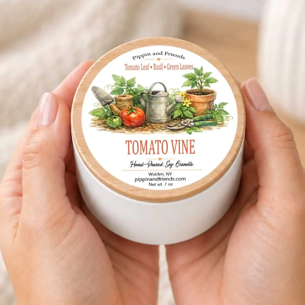 A person's hands holding a white container with a label featuring an illustration of a tomato vine and various gardening tools.