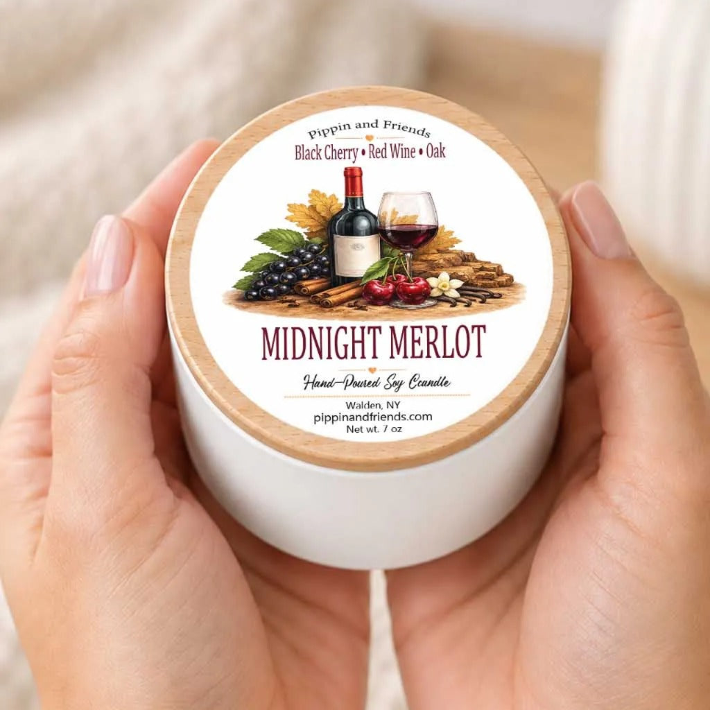 A person's hands holding a white container with a label that features an illustration of wine, grapes, and other wine-related items.