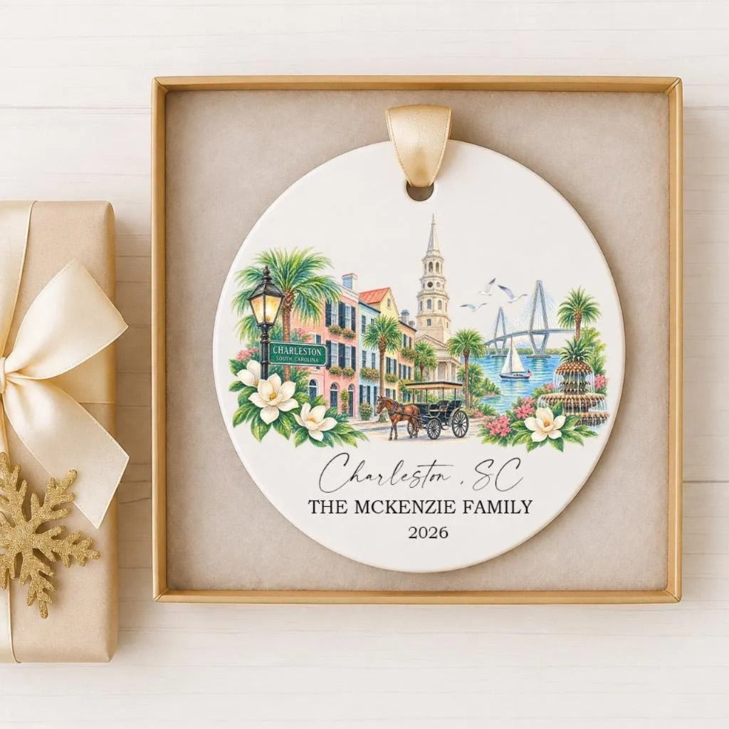 A decorative ornament featuring a cityscape with a horse-drawn carriage, palm trees, and a bridge, along with the text "Charleston, SC THE MACKENZIE FAMILY 2026".
