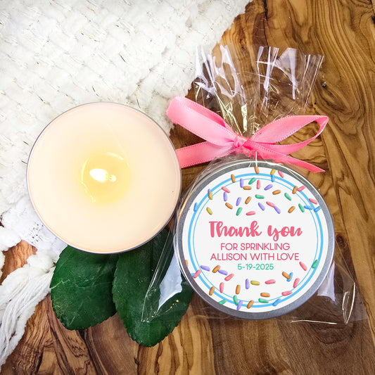 a white candle and a pink ribbon on a table
