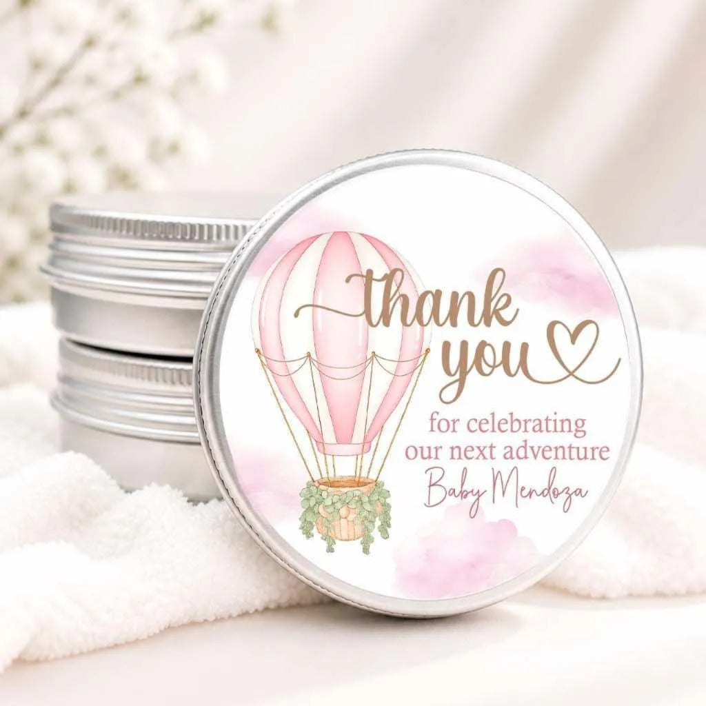 A round tin lid with a pink hot air balloon design and a heart-shaped "Thank you" message.