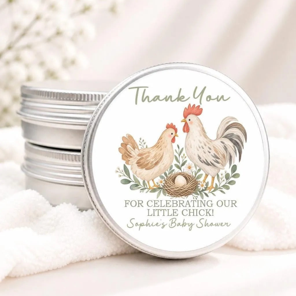A round tin lid with a label that says "Thank You" and features illustrations of two roosters standing next to a nest with an egg.