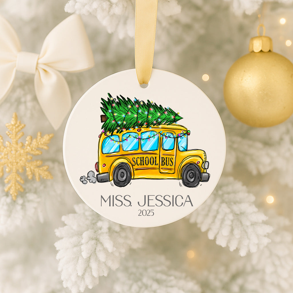 A round ornament featuring a yellow school bus carrying a Christmas tree, with the name "Miss Jessica" and the year "2025" printed on it.