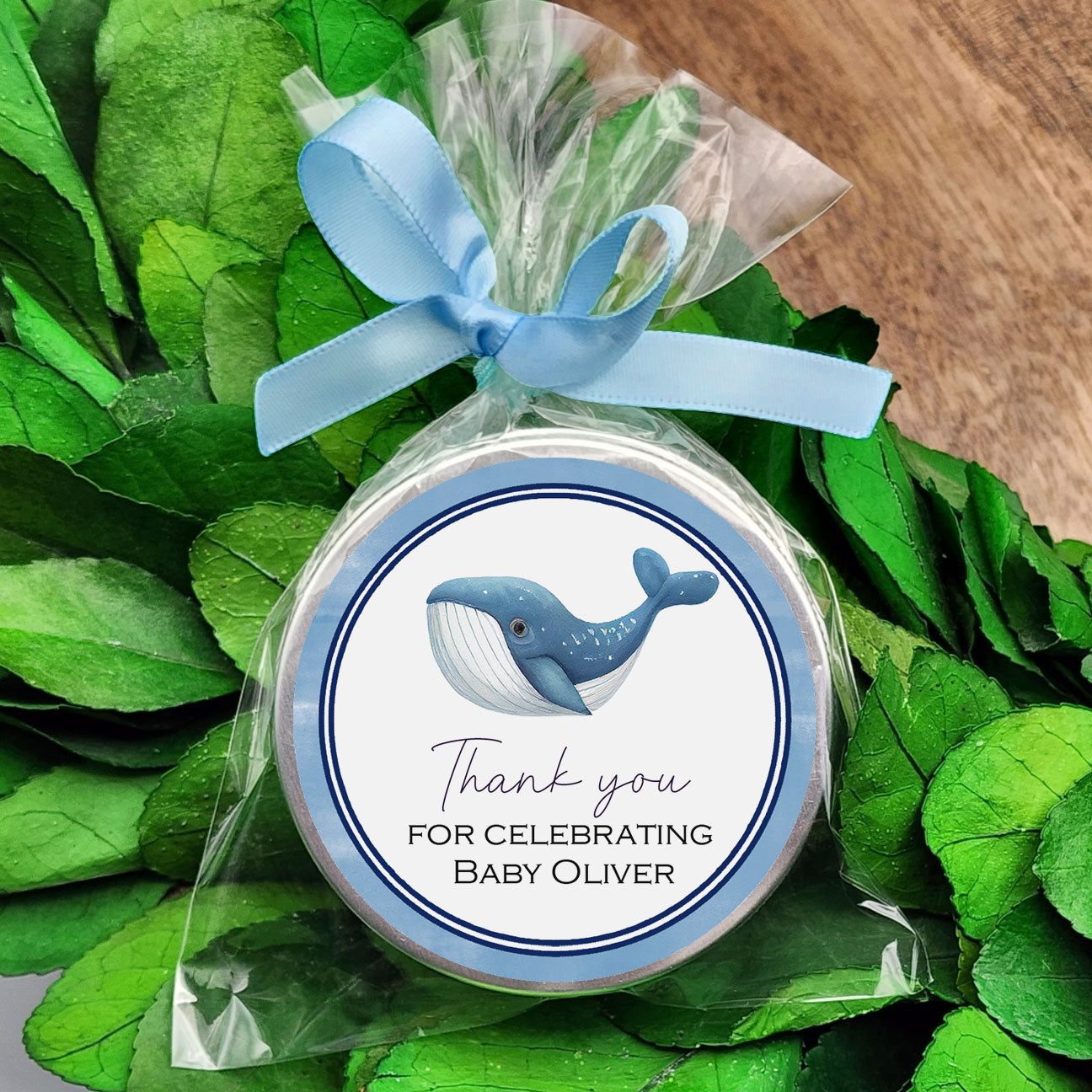 a blue and white whale baby shower ornament on a wreath