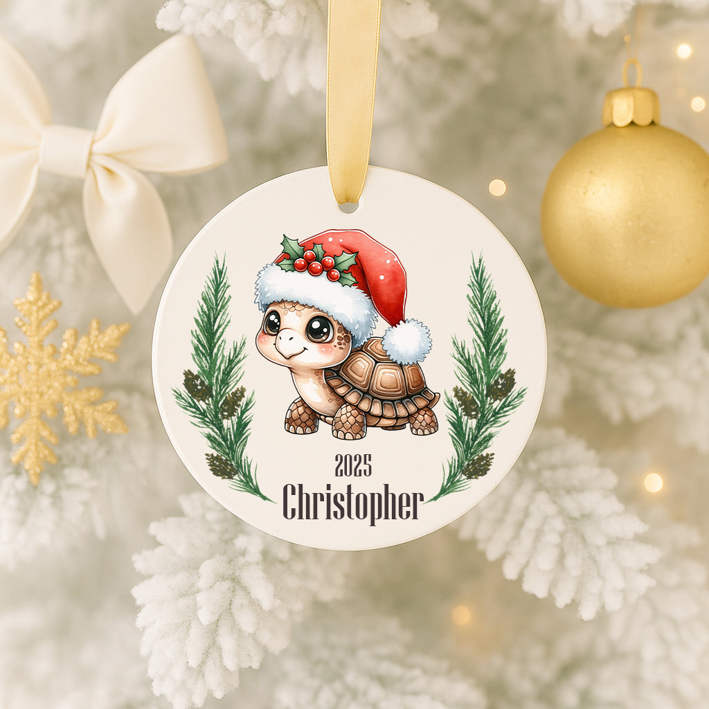 A Christmas ornament featuring a cartoon turtle wearing a Santa hat, surrounded by pine branches and a snowflake.