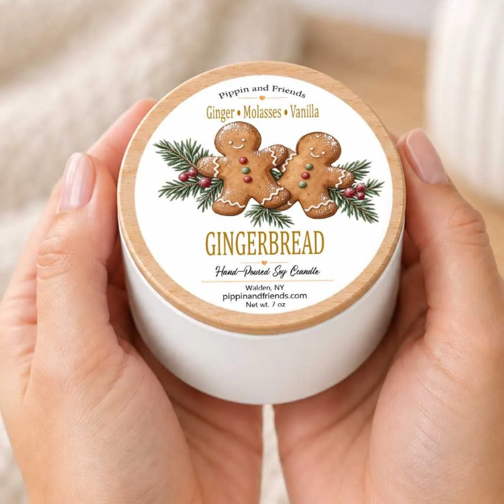 A person's hands holding a white container with a label featuring a gingerbread and vanilla scent.