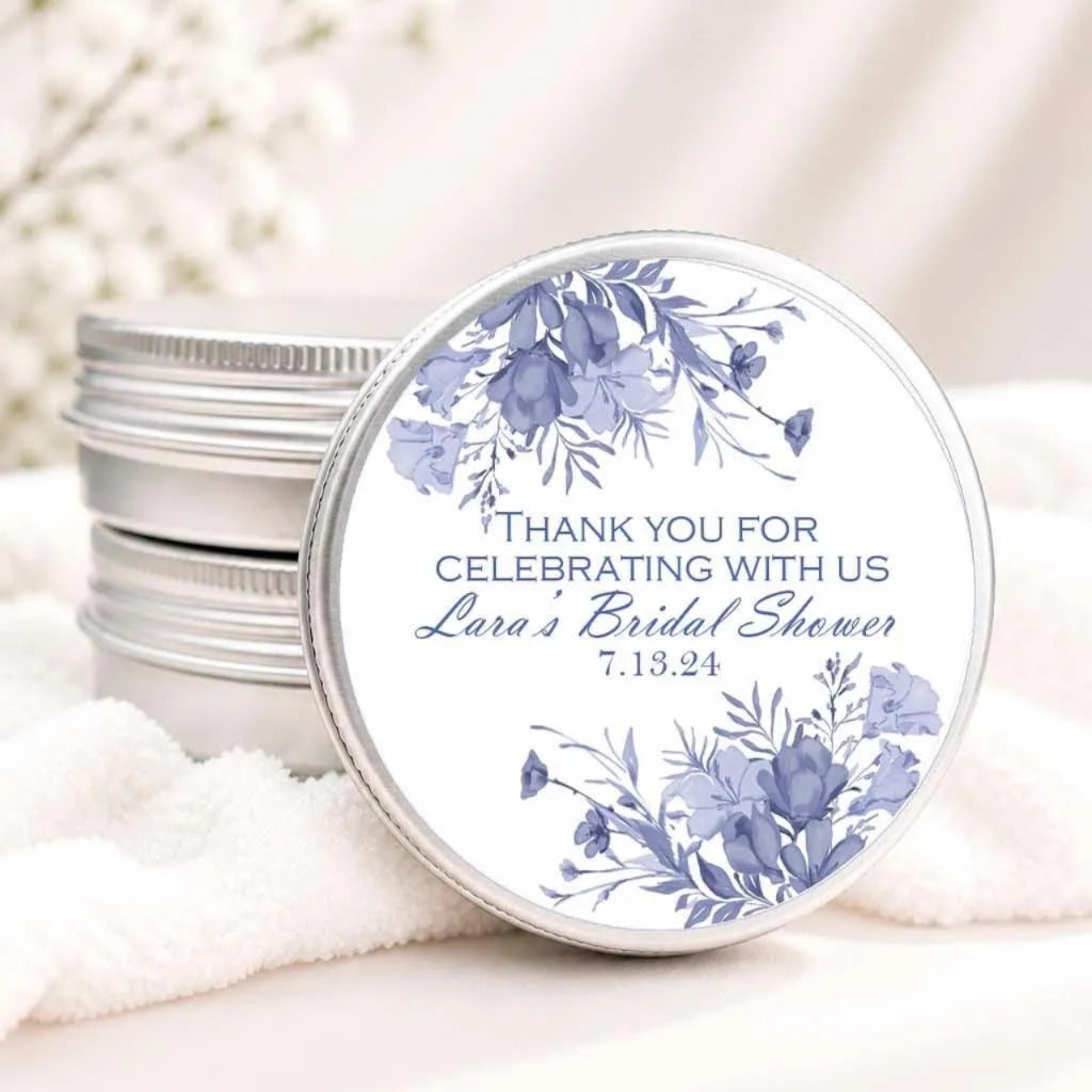 A round tin lid with a floral design and text on it, placed on a white cloth.