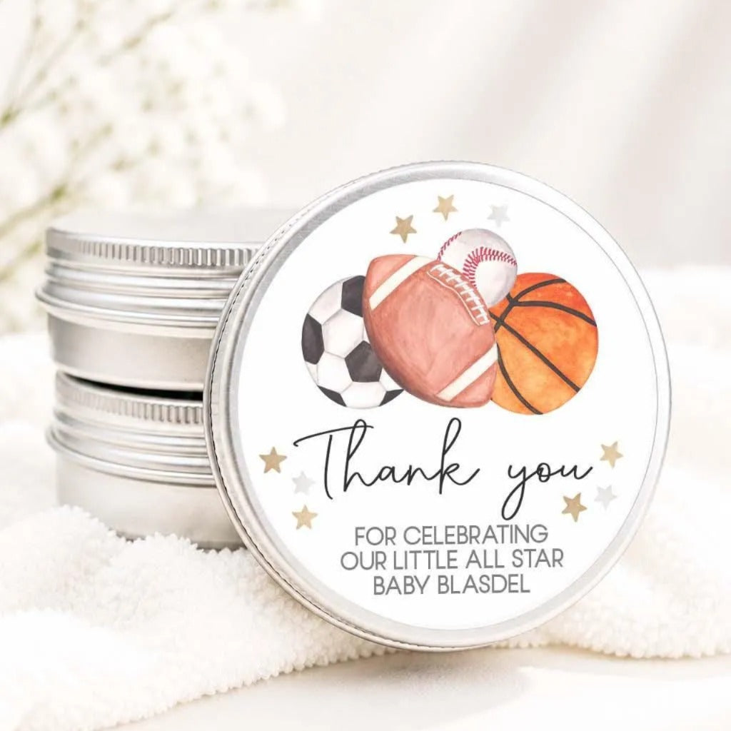 A round tin lid with a sports ball and a baseball on it, along with a message that says "Thank you for celebrating our little all star baby bladel".